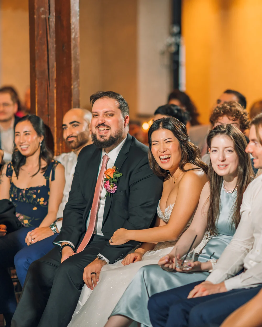 Les mariés rient pendant la prestation de Bao à leur mariage